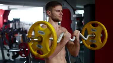 Spor salonunda, kaslı kollarını salıncak kılıyor
