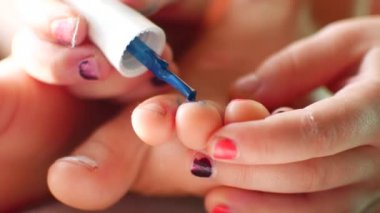 Bebek onun ayak tırnaklarını boyar. Yakın çekim.