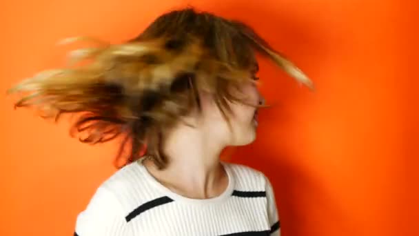 Adolescente agitando su cabello sobre un fondo de coral — Vídeos de Stock