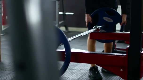 Close-up macro dicht omhoog van knappe bodybuilder man voor te bereiden op doen oefeningen met barbell in een sportschool, barbell plaat in handen houden, sport man — Stockvideo