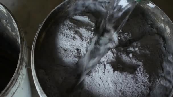 Працівник додає воду в ємність з сірим декоративним бетоном — стокове відео