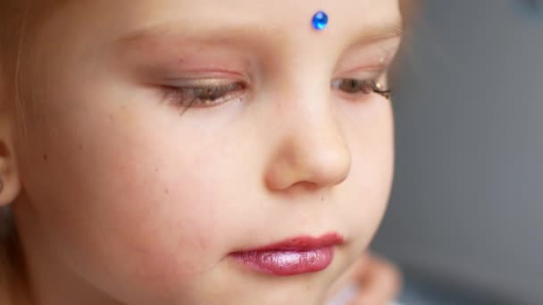 Em casa, no quarto, mãe e filha brincam e se maquilham. A mãe e a filha sorrindo enquanto tentam truques de beleza. Conceito: beleza, família, diversão, memórias . — Vídeo de Stock