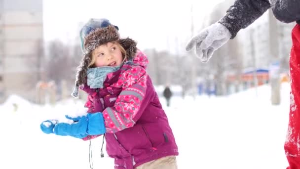 Der hübsche junge Papa und seine kleine süße Tochter amüsieren sich im Winter im Freien. Zeit miteinander zu verbringen und dabei Schnee-Engel zu basteln. Familienkonzept — Stockvideo