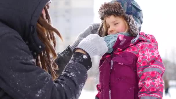 잘생긴 젊은 아버지와 그의 귀여운 작은 딸 재미 있습니다 겨울에 야외. 눈 천사를 만드는 동안 함께 시간을 보내고 즐기는. 가족 개념 — 비디오