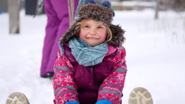 家庭在冬季公园散步。父母与孩子在雪橇上 — 图库视频影像