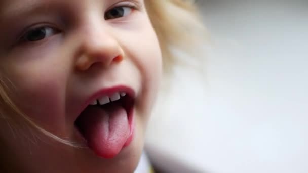 Niña niña cara retrato mueca mostrar lengua a cámara — Vídeo de stock