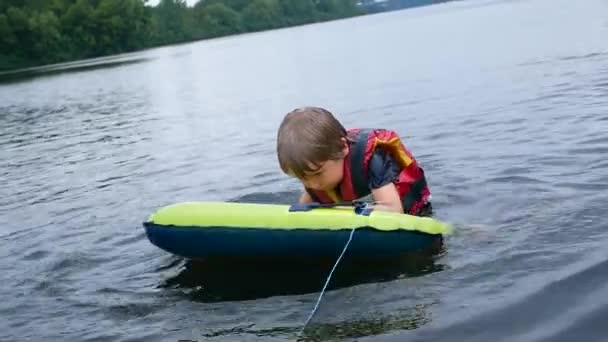 El niño flota en el río, el chaleco salvavidas en acción — Vídeos de Stock