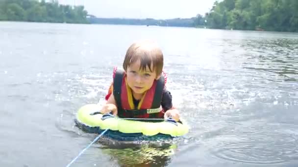 The boy floats in the river, the life jacket in action — Stock Video