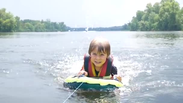 De jongen zweeft in de rivier, het zwemvest in actie — Stockvideo