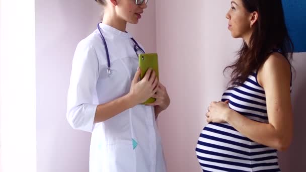 Ciąży, ginekologii, medycyny, opieki zdrowotnej i koncepcja ludzie - lekarz ginekolog i spotkanie w szpitalu kobieta w ciąży. — Wideo stockowe