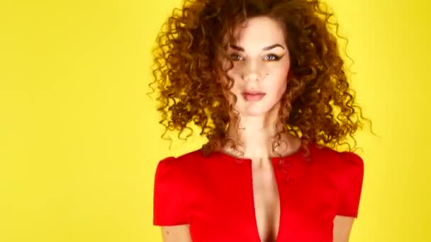 Beautiful young woman in red dress jumps. Curly hair flying up and down. 4k. — Stock Video
