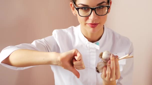 Jonge vrouw arts beveelt knoflook als een remedie voor onvruchtbaarheid en impotentie. — Stockvideo