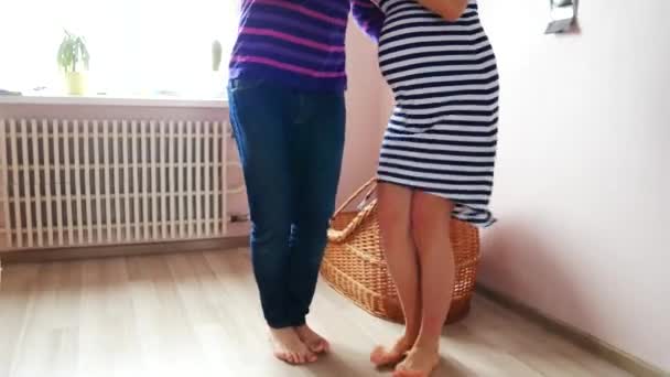 Egy férfi és egy terhes nő táncolnak a kiságy közelében. Várakozás, terhesség, családi. — Stock videók