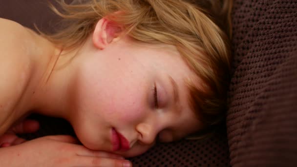 Rusteloze slaap van een kind. Het meisje draait in een droom — Stockvideo