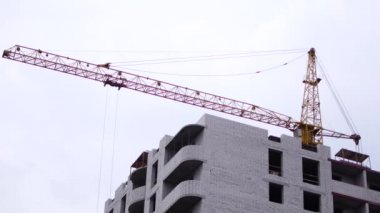 Çok katlı, tuğla bina inşaatı. Montaj vinç leri yapı malzemelerini kaldırır.