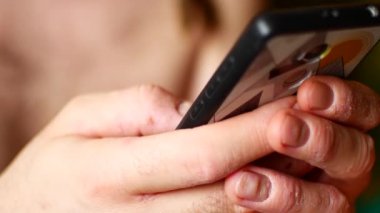 Bir adam cep telefonu kullanıyor. Videoda, sadece erkek elleri.