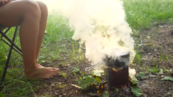 Camping i skogen. En kastrull med mat kokar på spisen. Rök kommer från elden. — Stockvideo