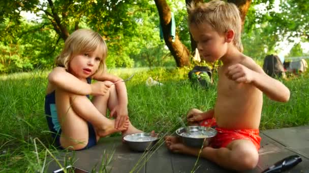 Les enfants mangent du porridge dans la nature au camping — Video
