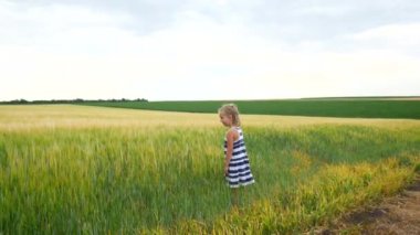 Çocuk kız bir alanda çekirge veya kelebekler yakalar