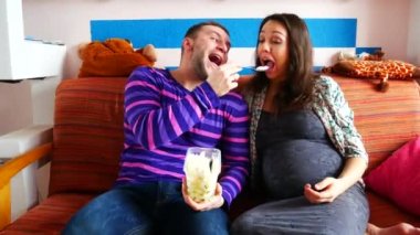 Genç çift kanepede oturan, dondurma ile birbirlerine beslenme