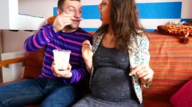 Genç çift kanepede oturan, dondurma ile birbirlerine beslenme