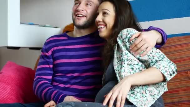 Пара с беременной женщиной, отдыхающей на диване — стоковое видео