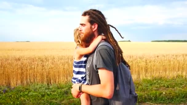 Pappa bär dotter i famnen. Promenad på landsbygden. — Stockvideo