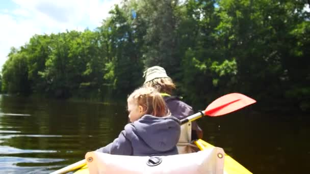 Ett barn paddlar på en kajak paddel. Aktiv familjesemester. — Stockvideo