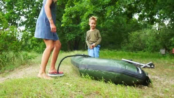 Una mujer está bombeando un barco inflable con una bomba de pie . — Vídeos de Stock