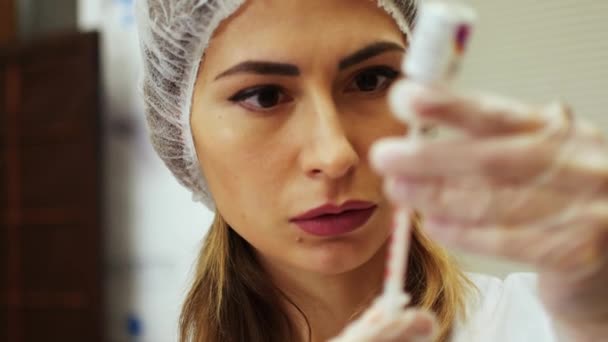 Een vrouw bereidt een injectiespuit voor. — Stockvideo