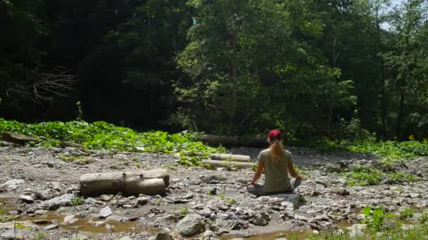 Kaukasisk kvinna mediterar i en skog i en clearing. Lugn i ren natur. — Stockvideo