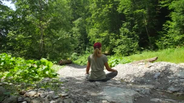 Blanke vrouw mediteren in een bos in een clearing. Kalm in puur natuur. — Stockvideo