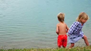 Childs erkek ve kız kardeşi göl yakınında oynamak
