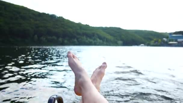 Descansa en un barco. Piernas sobre el fondo del agua de mar . — Vídeos de Stock