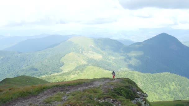 En grupp turister stiger till toppen av en bergskedjan. — Stockvideo