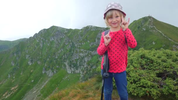 Niña en la cima de la montaña. Muestra dedos de roca . — Vídeos de Stock