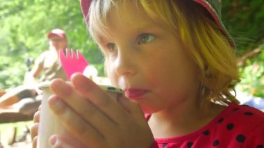 Çocuk bir bardaktan çay içer. Yürüyüş rotasında yürüyüşe çıkın.