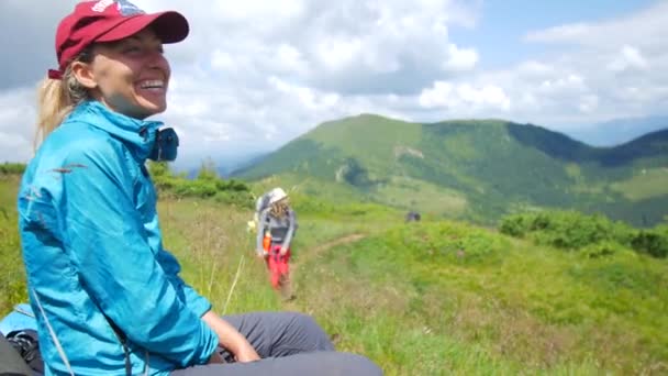 Lány ül pihenő után túrázás a hegyekben — Stock videók