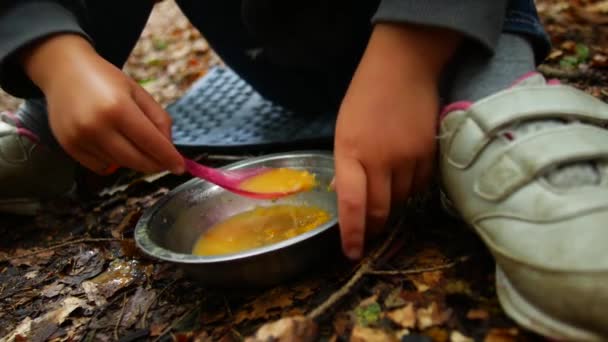 Il concetto del pranzo in campeggio. Bambino mangia porridge . — Video Stock