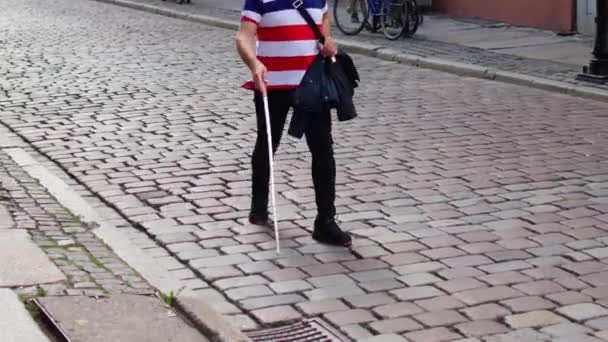 Blind man går på trottoaren med en käpp — Stockvideo