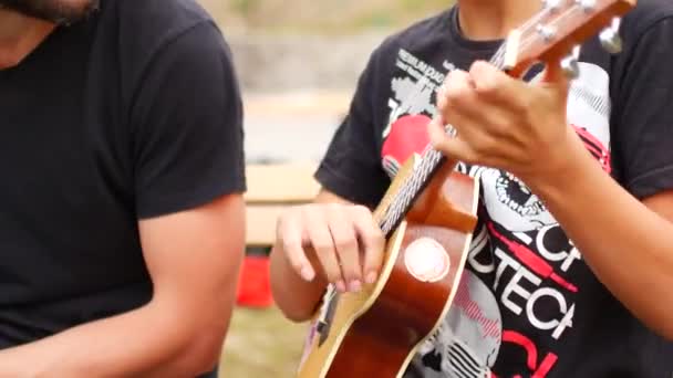 Barn spelar gitarr, ukulele. Närbild — Stockvideo