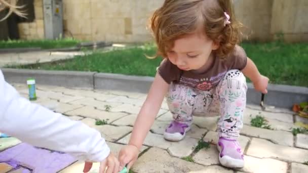 Kinderen tekenen met krijt op de stoep — Stockvideo