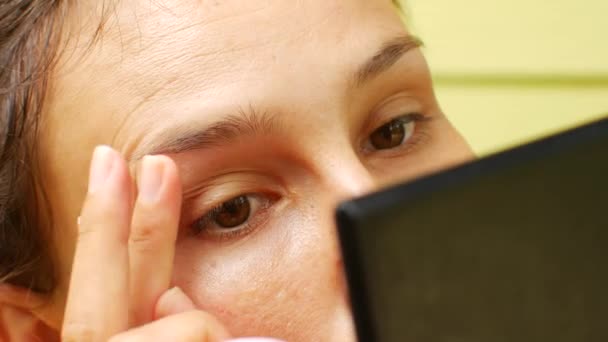 Uma mulher contrai as sobrancelhas sozinha — Vídeo de Stock
