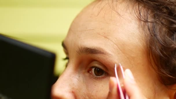 Uma mulher contrai as sobrancelhas sozinha — Vídeo de Stock