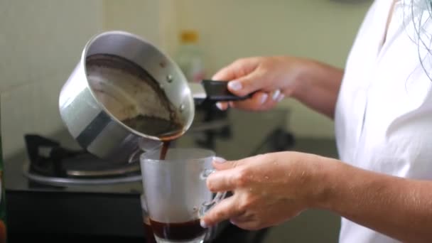 Mujer vertiendo café caliente en una taza — Vídeo de stock