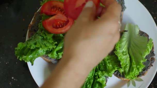 Kobieta przygotowująca kanapki z liśćmi sałaty — Wideo stockowe