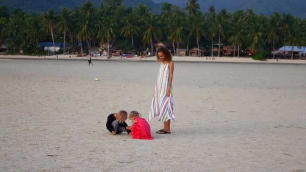 Mamma con due figlie cammina lungo la spiaggia al tramonto — Video Stock