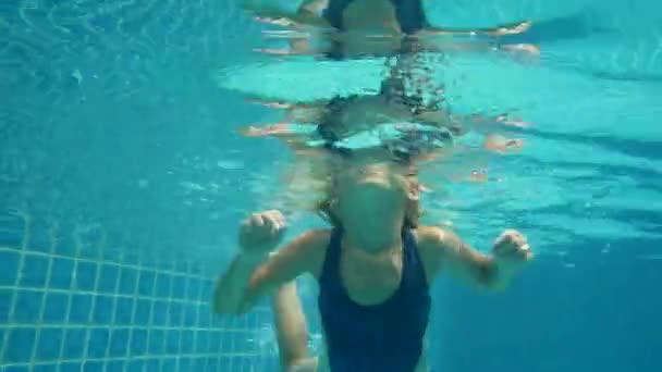 Niña de 6 años bucea en la piscina, disparando bajo el agua — Vídeos de Stock