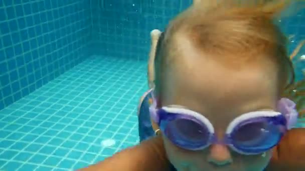6 år gammal flicka dyker i poolen, undervattensfotografering — Stockvideo