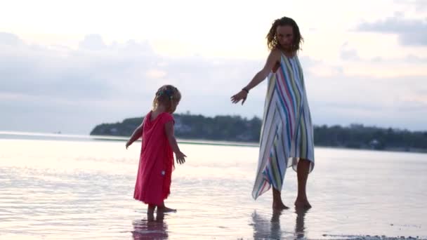 Moeder en dochter spelen op de ondiepten bij zonsondergang — Stockvideo